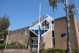 Bloemen en vlaggen halfstok voor overleden motoragent