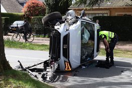 Auto belandt op zijkant na botsing tegen boom