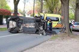 Auto belandt op zijkant na botsing tegen boom