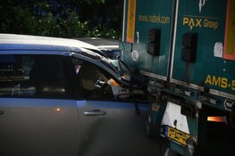 Auto botst achterop lossende vrachtwagen in Hilversum