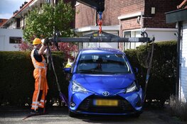 Automobilist rijdt per ongeluk achteruit en komt met voertuig vast in heg te zitten