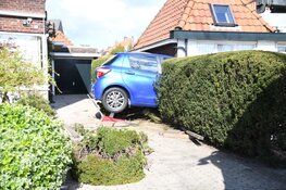 Automobilist rijdt per ongeluk achteruit en komt met voertuig vast in heg te zitten